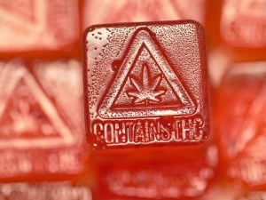 Red chewy candy with imprint of words Contains THC